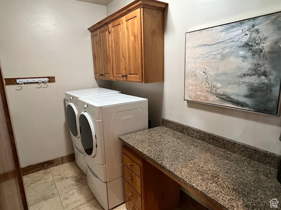 Washroom with baseboards, washer and clothes dryer, and cabinet space