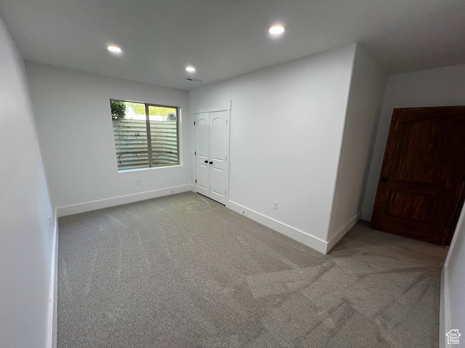Carpeted empty room with recessed lighting, baseboards, and visible vents