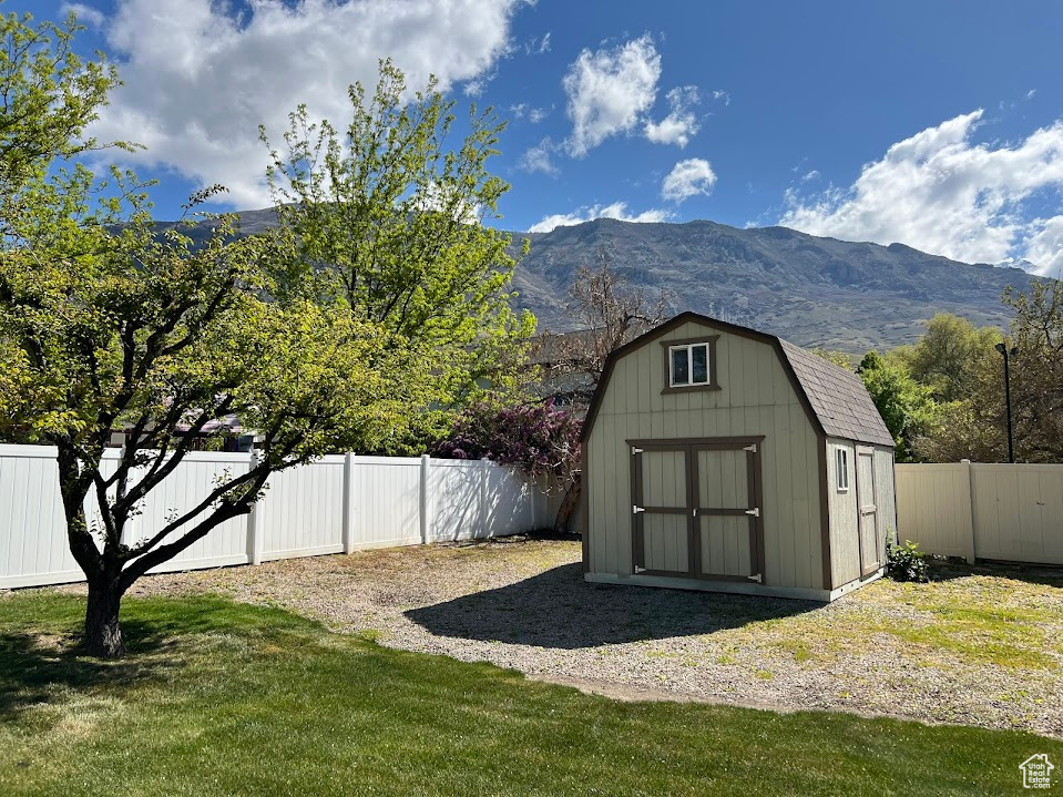 View of shed with a fenced backyard and a mountain view