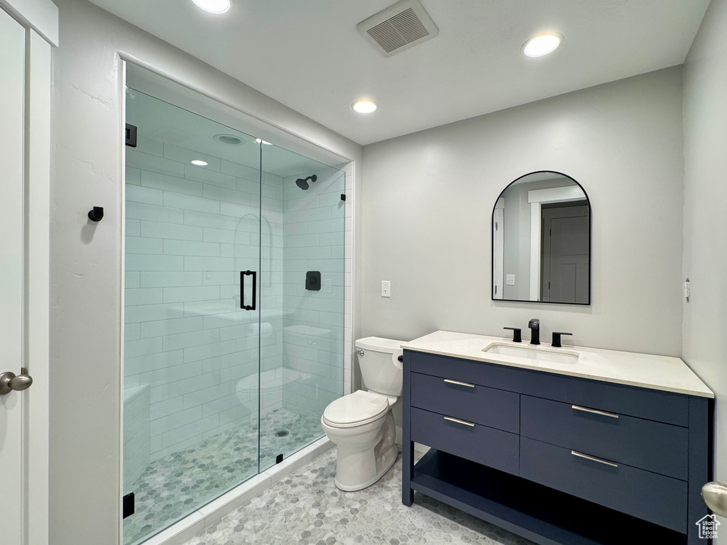 Full bathroom featuring vanity, toilet, recessed lighting, a shower stall, and visible vents