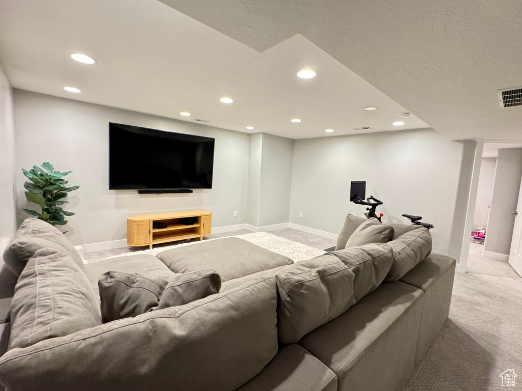 Living room with recessed lighting, baseboards, visible vents, and light carpet