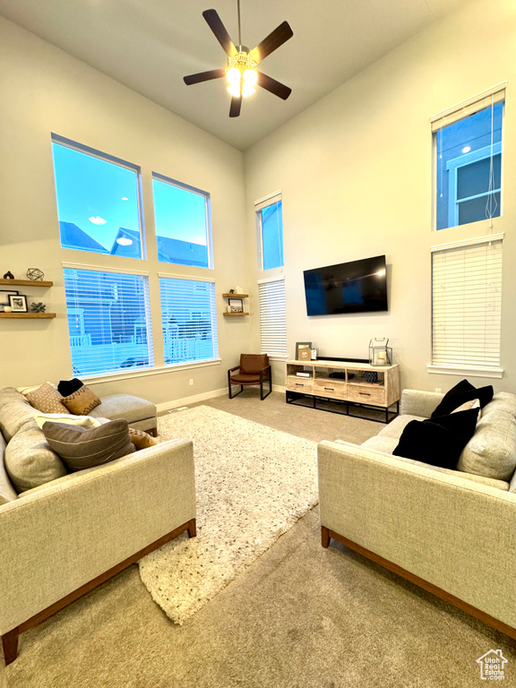 Living room with baseboards, ceiling fan, and carpet flooring