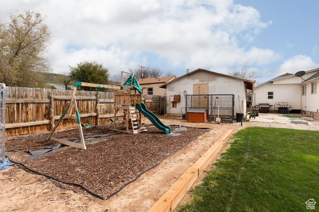 View of play area with a fenced backyard and a yard