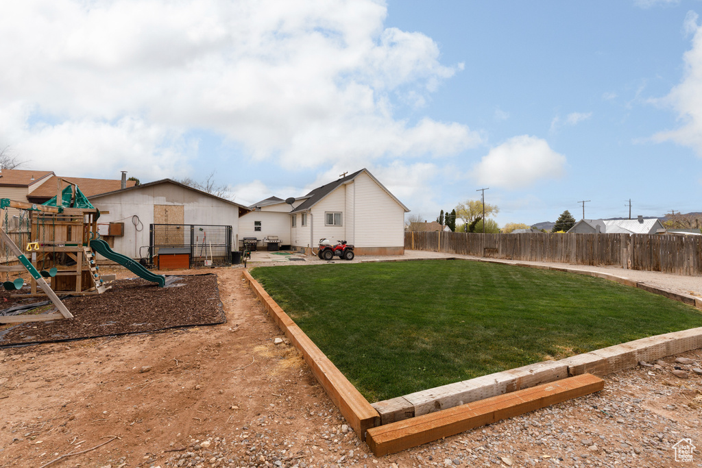 View of yard with a fenced backyard and a playground