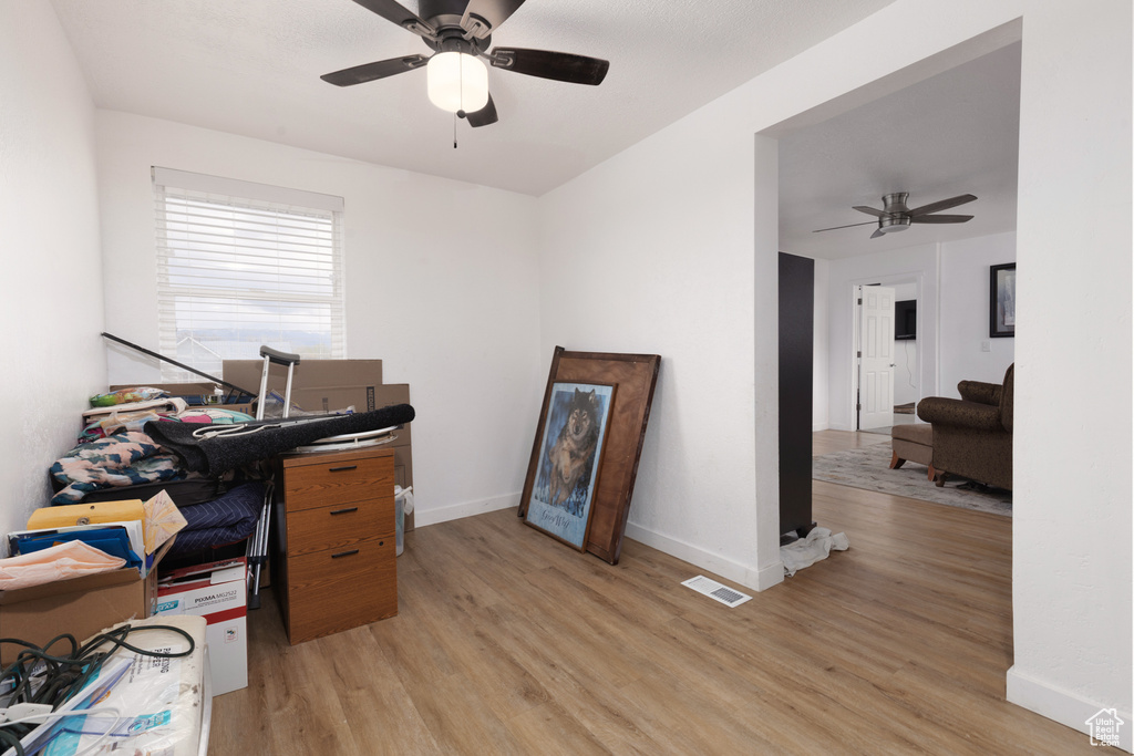 Office area with baseboards, ceiling fan, light wood-style flooring, and visible vents