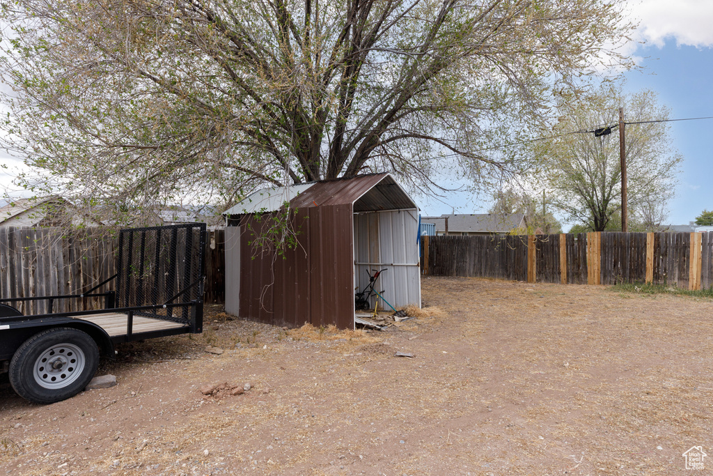 View of yard with fence, an outbuilding, and a storage shed
