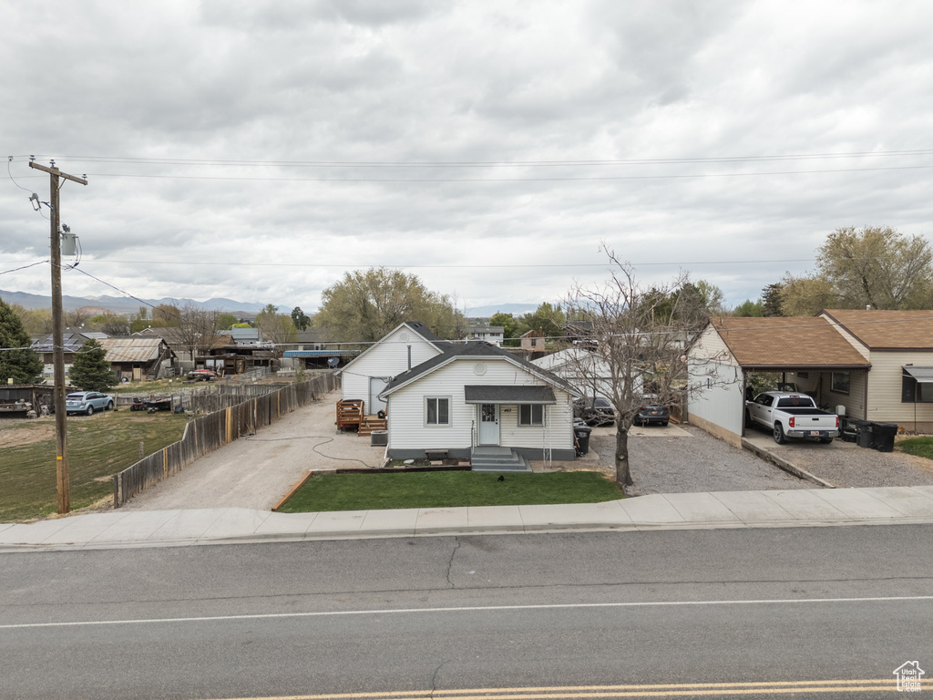 Bungalow-style home featuring fence, driveway, a front yard, and entry steps