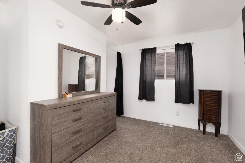 Carpeted bedroom featuring baseboards, a ceiling fan, and visible vents