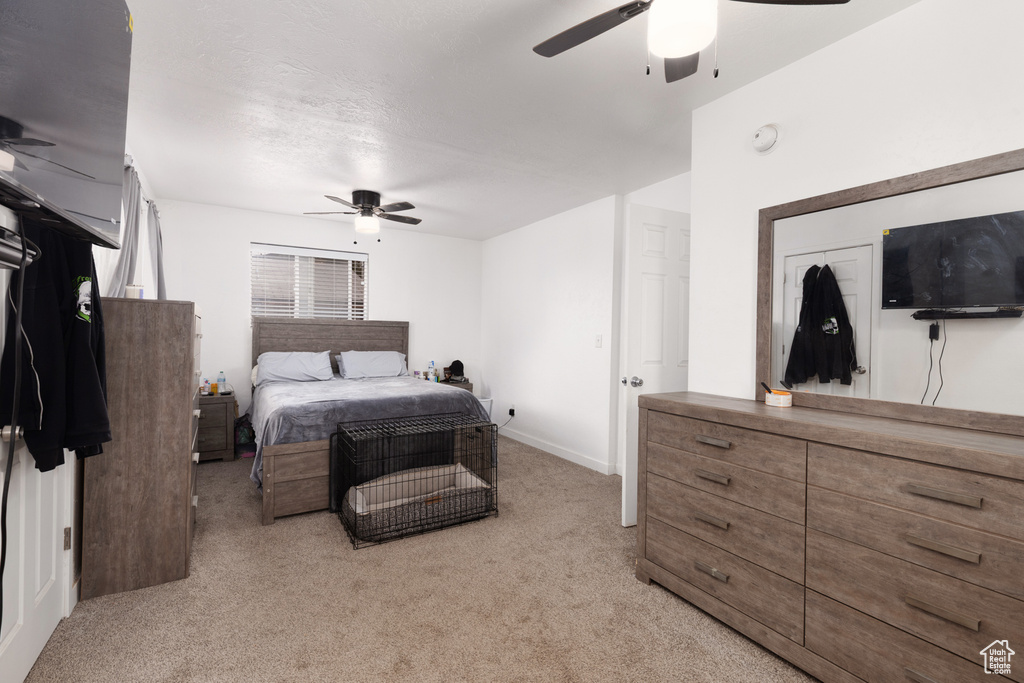 Bedroom featuring baseboards, a ceiling fan, and light colored carpet