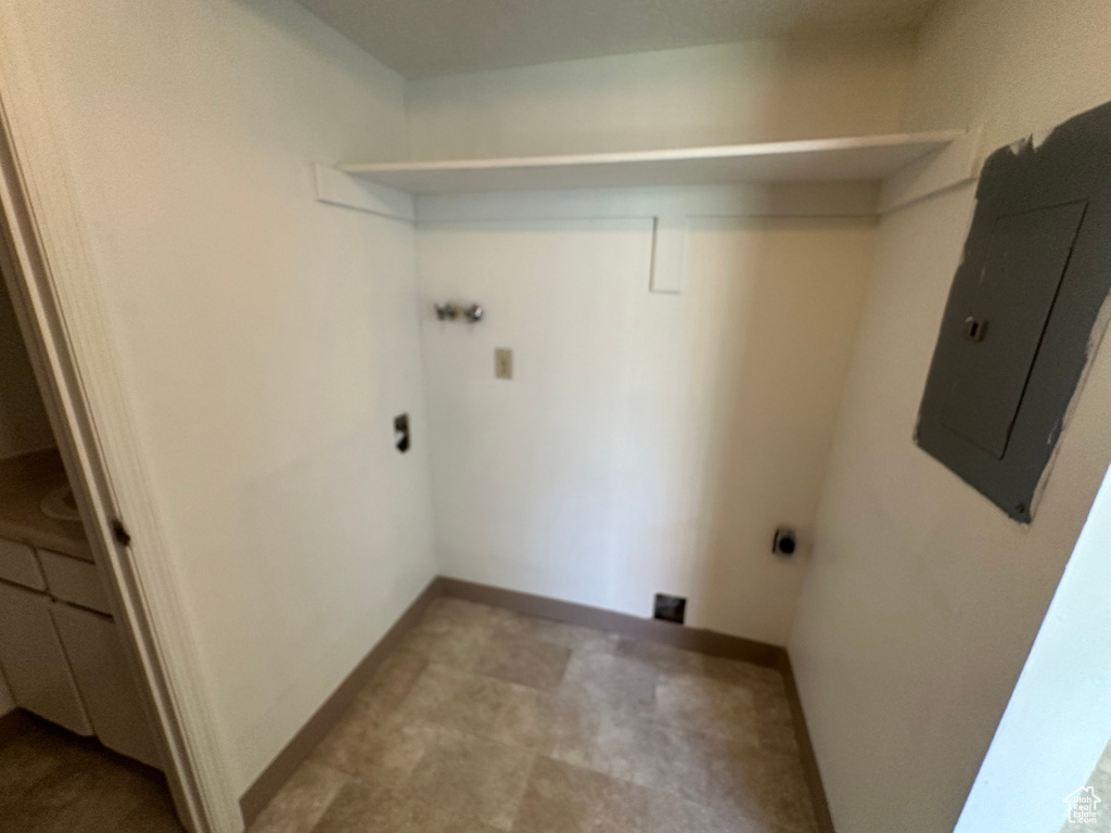 Laundry room with hookup for an electric dryer, laundry area, baseboards, and electric panel