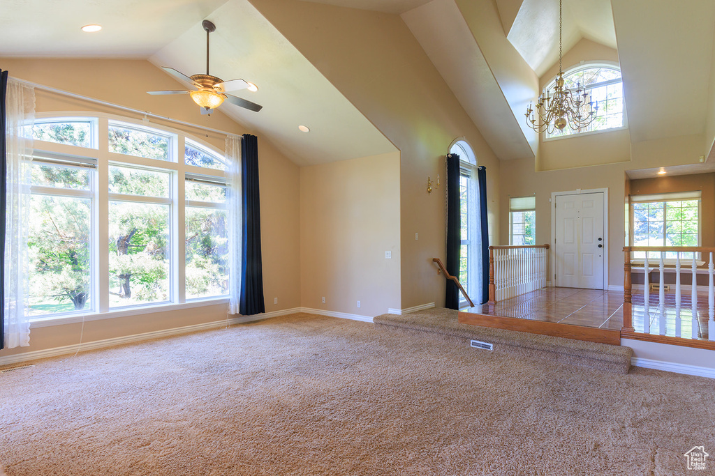 Unfurnished living room featuring carpet floors, baseboards, visible vents, and a healthy amount of sunlight