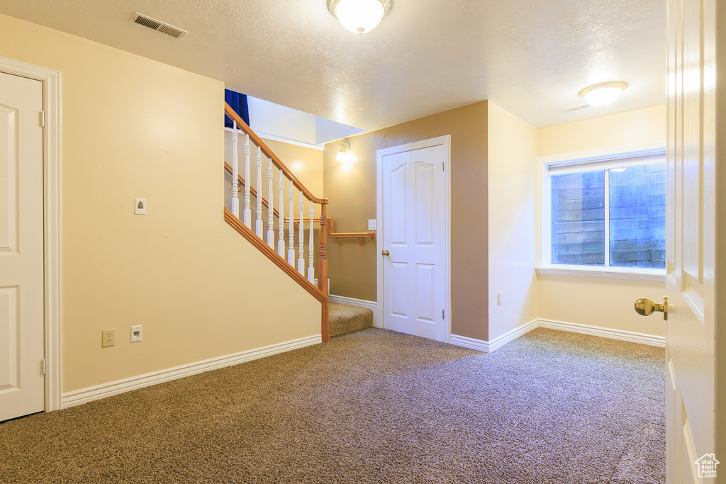 Interior space featuring baseboards, carpet, stairs, and visible vents