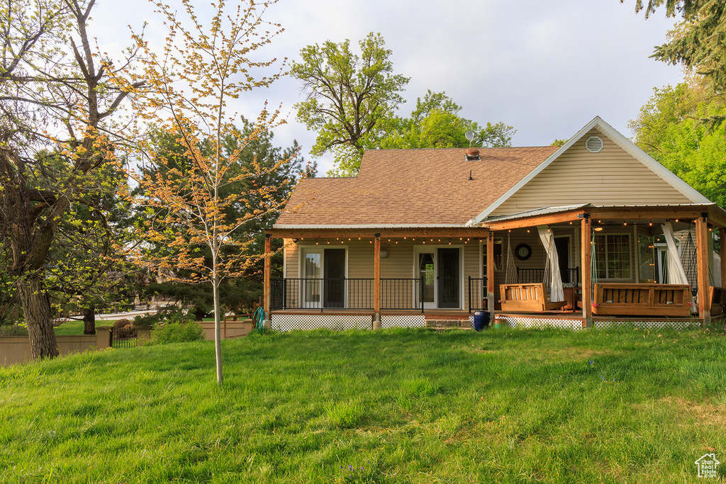 Rear view of house with a yard and roof with shingles