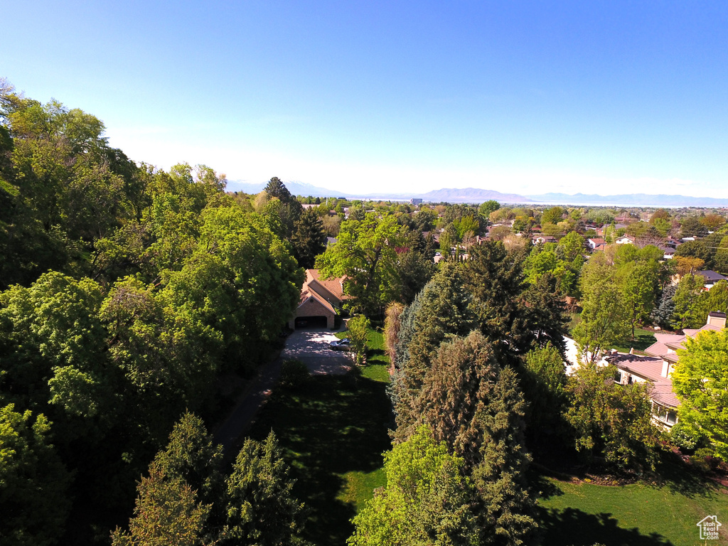 Birds eye view of property with a wooded view