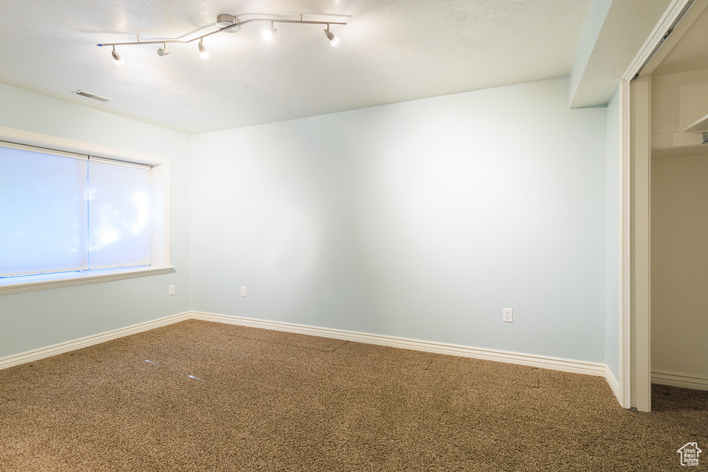 Unfurnished room featuring baseboards, carpet flooring, and visible vents