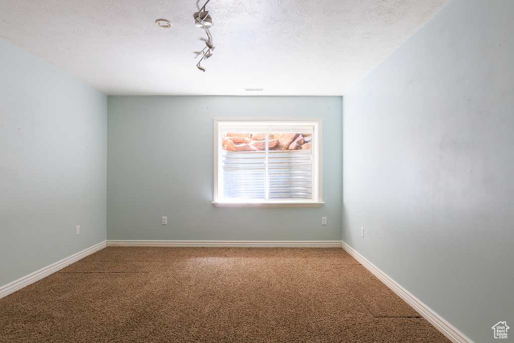 Unfurnished room featuring baseboards and carpet