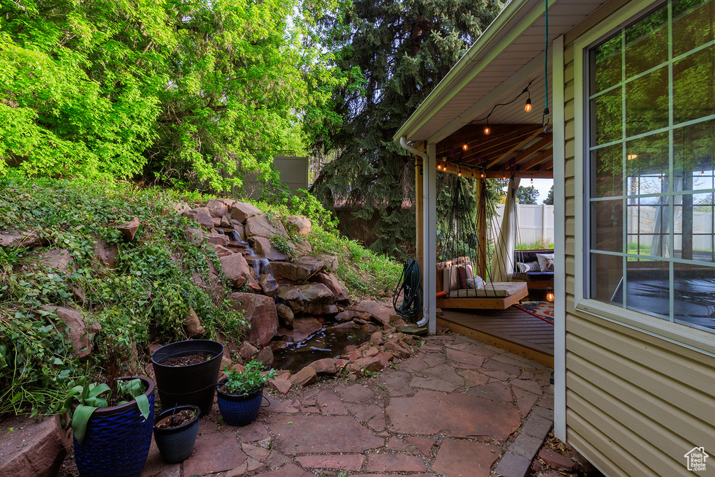 View of patio with a deck and fence