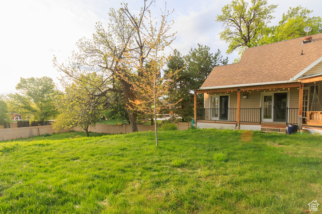 View of yard with covered porch and fence