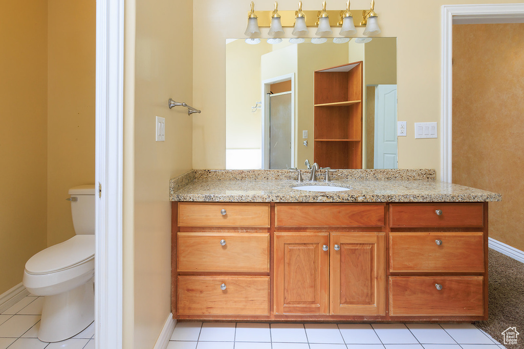 Full bathroom with an enclosed shower, tile patterned flooring, baseboards, vanity, and toilet