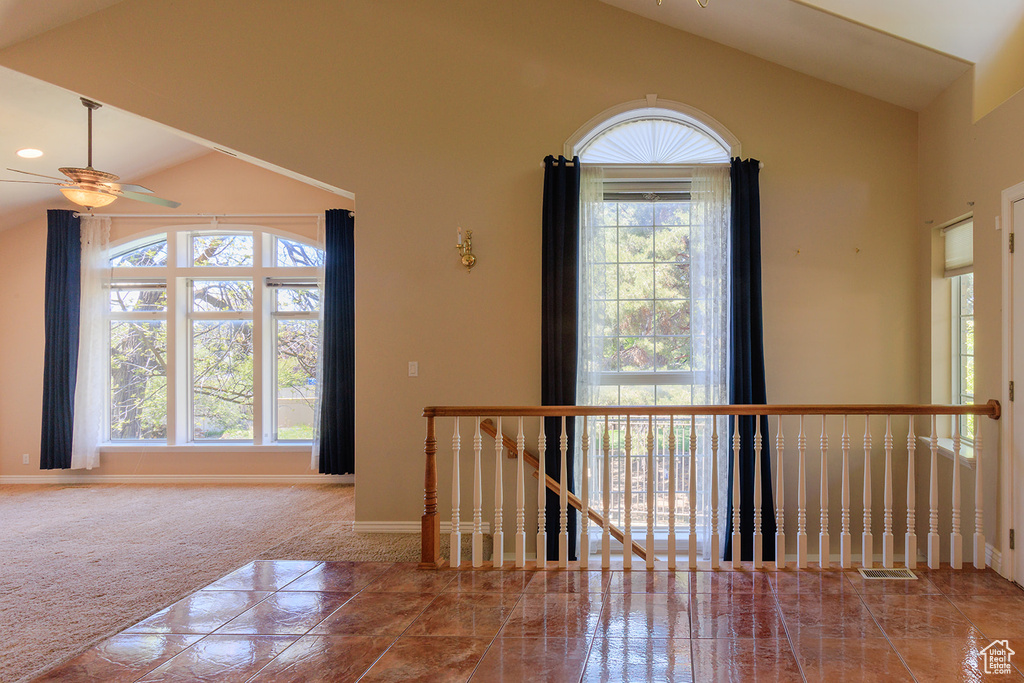 Entryway featuring visible vents, carpet flooring, baseboards, high vaulted ceiling, and a ceiling fan