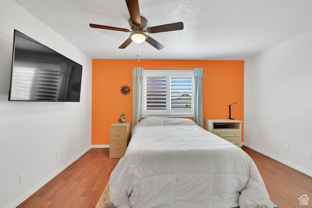 Bedroom featuring baseboards, a ceiling fan, and wood finished floors