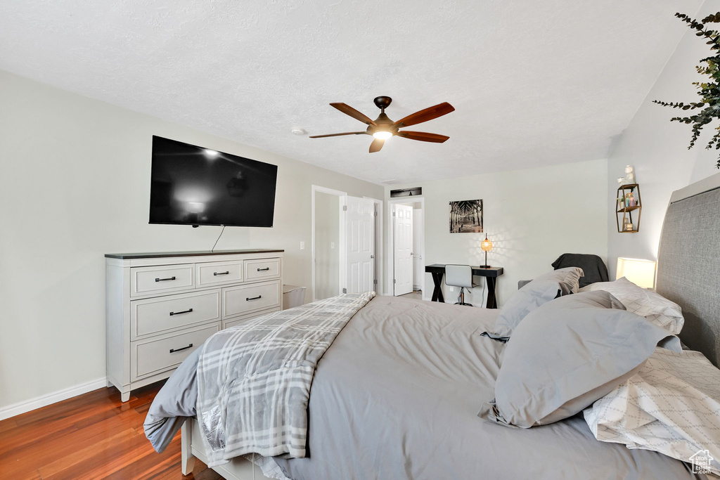 Bedroom with baseboards, a ceiling fan, and dark wood-style flooring