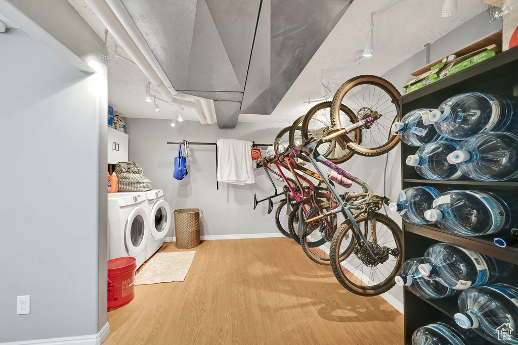Interior space with independent washer and dryer, baseboards, wood finished floors, and laundry area