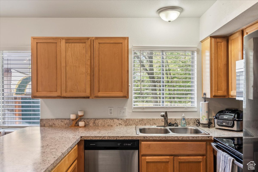 Kitchen featuring light countertops, stainless steel appliances, and a sink