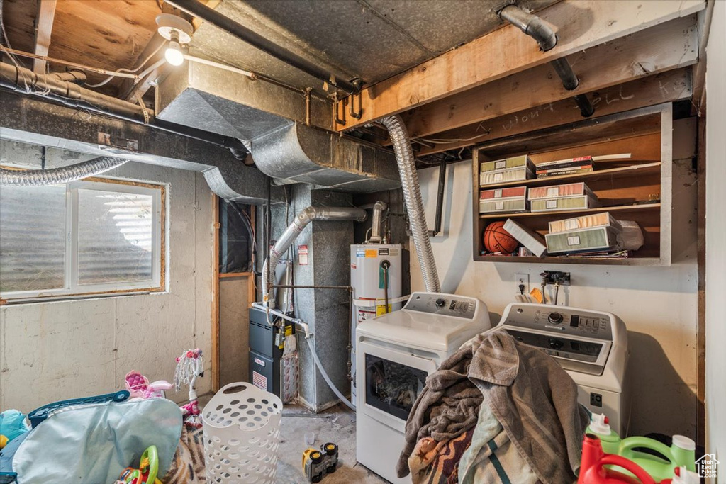 Utility room with water heater, heating unit, and washing machine and clothes dryer