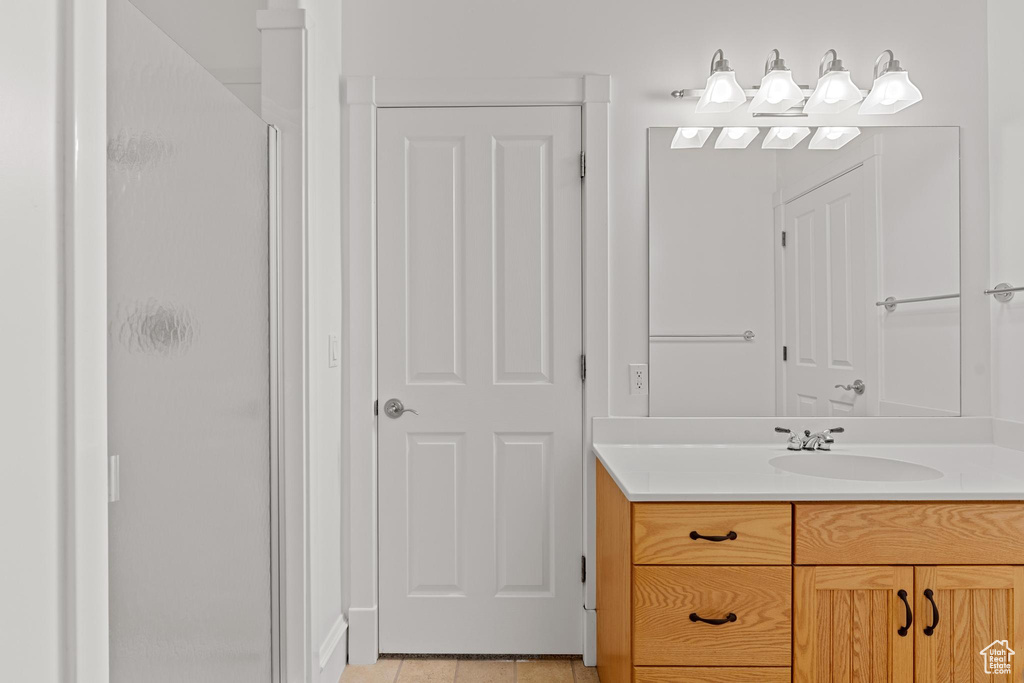 Full bath with vanity, tile patterned floors, and a stall shower