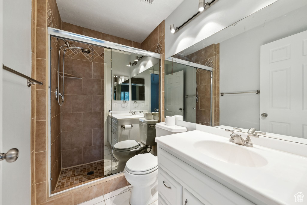 Full bathroom featuring vanity, tile patterned flooring, a stall shower, and toilet