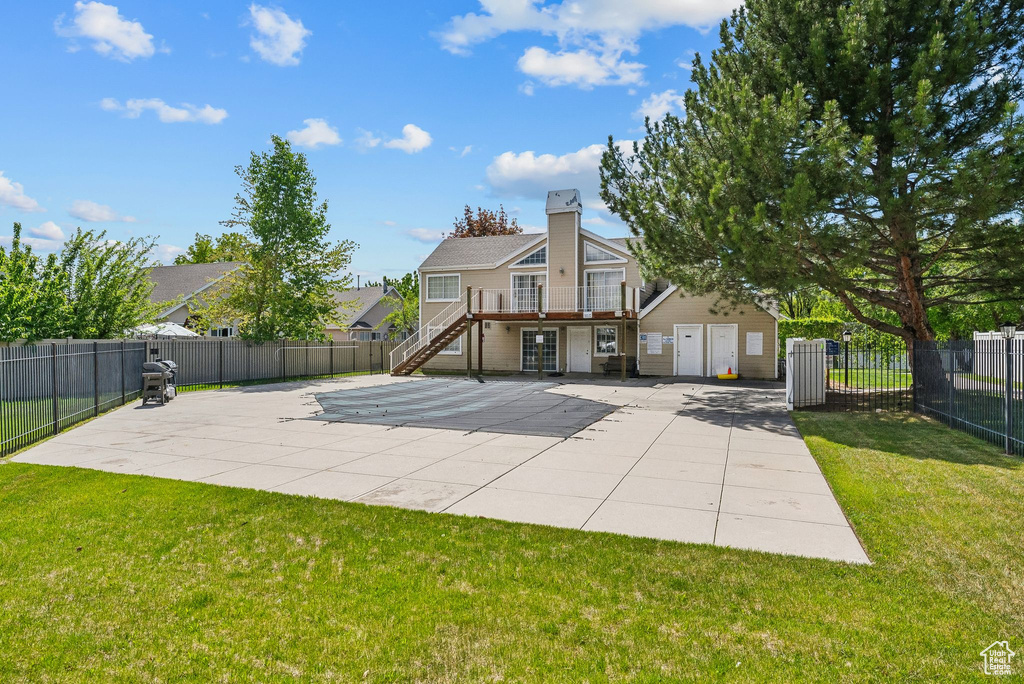 Back of property featuring a yard, a chimney, fence private yard, and stairs