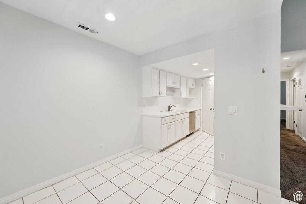 Kitchen featuring stainless steel dishwasher, visible vents, baseboards, light countertops, and a sink