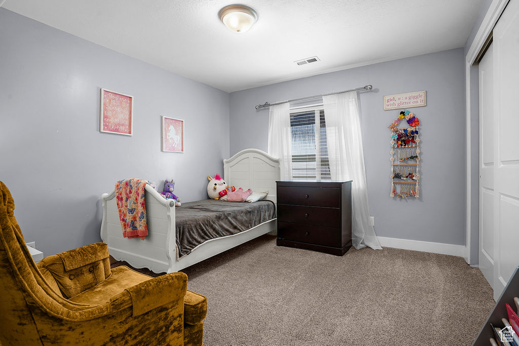 Bedroom with visible vents, baseboards, carpet floors, and a closet