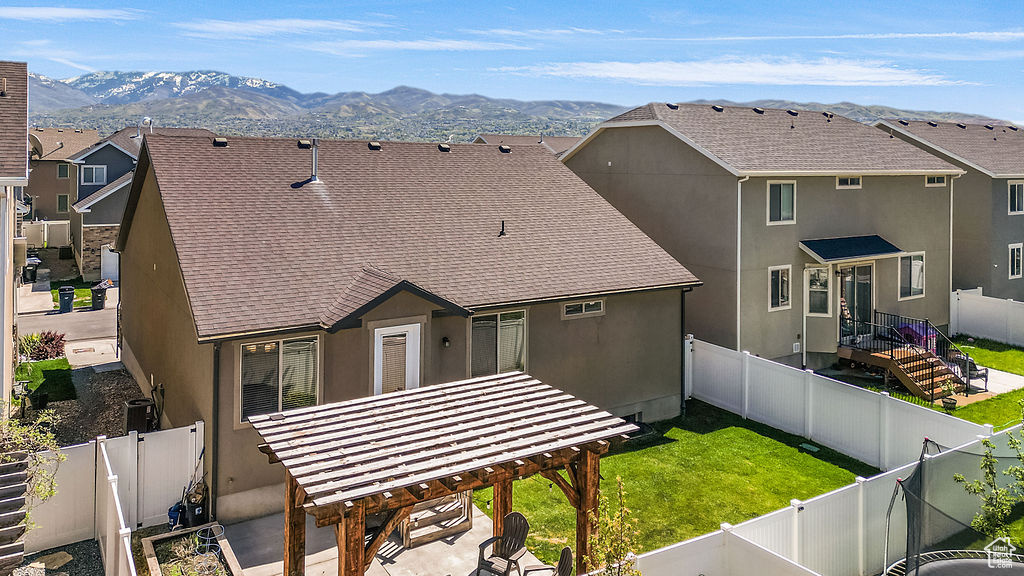 Rear view of property featuring a patio, a fenced backyard, roof with shingles, and stucco siding