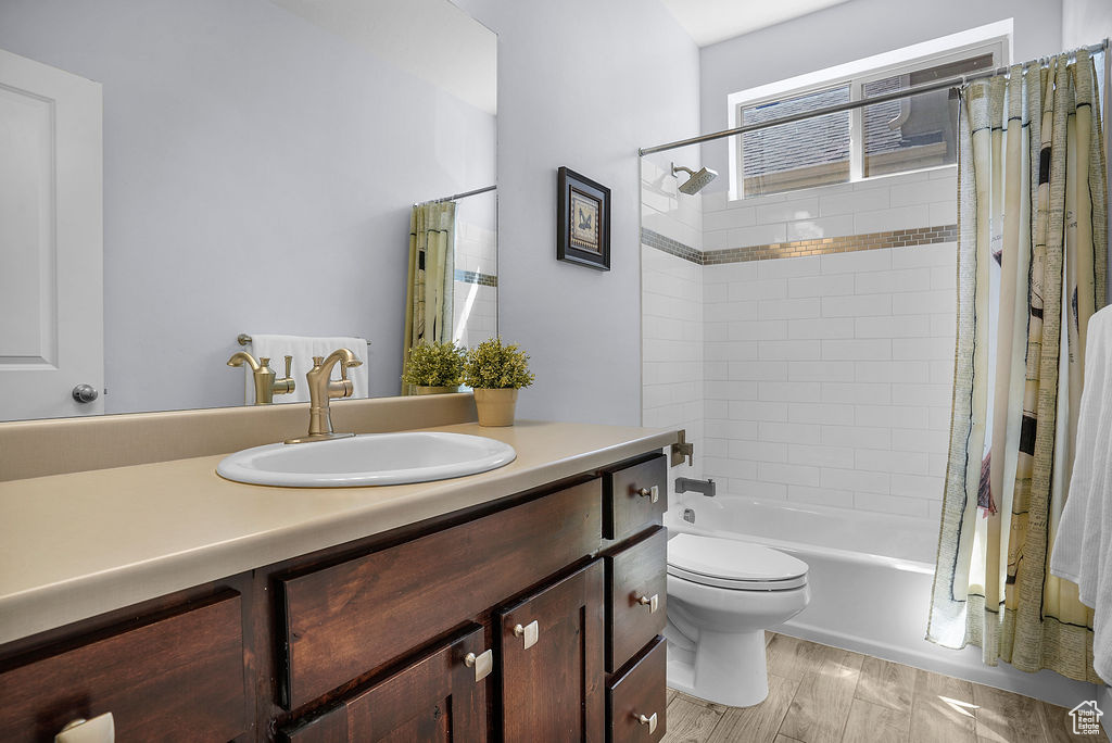 Full bath with vanity, toilet, and shower / tub combo with curtain
