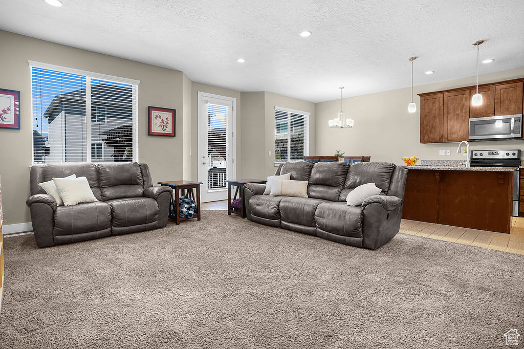Living room featuring plenty of natural light, recessed lighting, a textured ceiling, and a chandelier