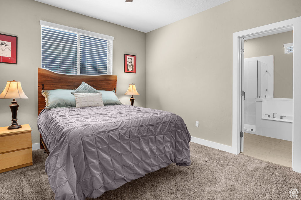 Bedroom featuring carpet floors, baseboards, and connected bathroom