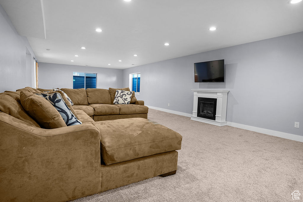 Living area featuring recessed lighting, baseboards, and light carpet
