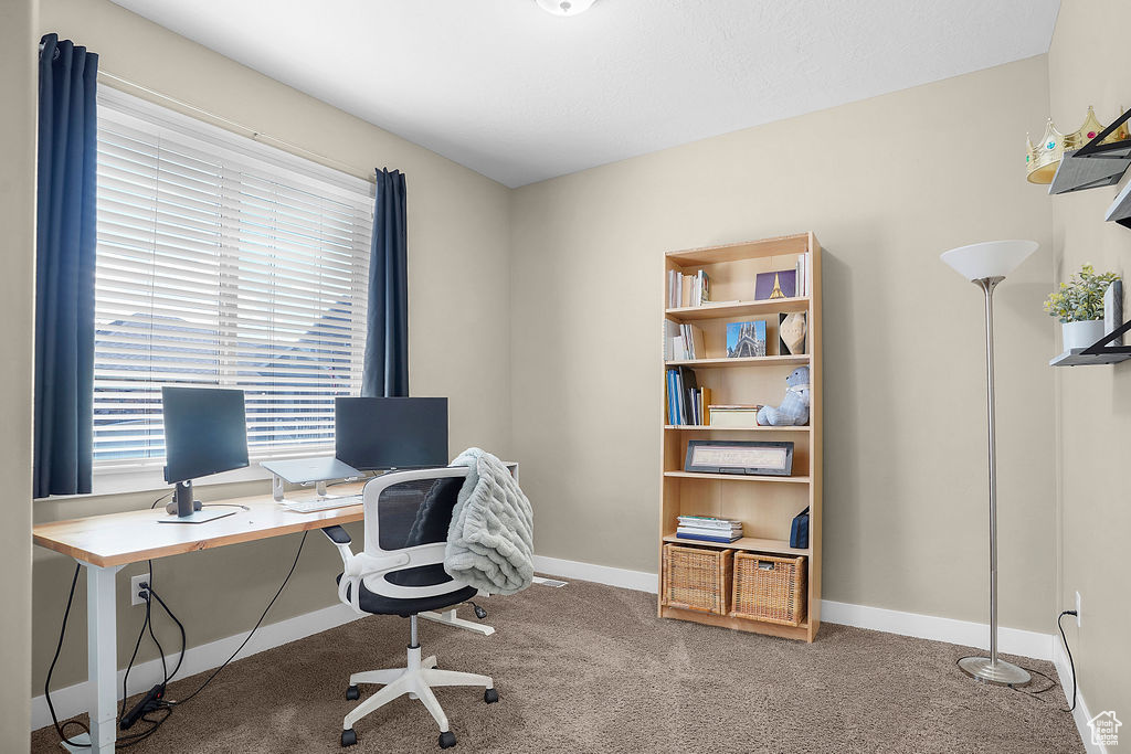 Carpeted office space featuring baseboards