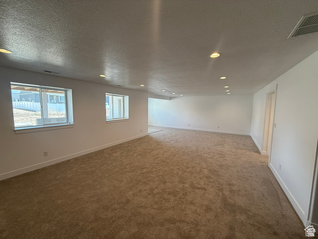Carpeted spare room with baseboards, recessed lighting, and a textured ceiling