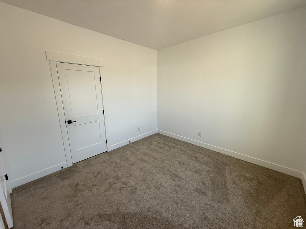 Unfurnished room featuring carpet floors and baseboards