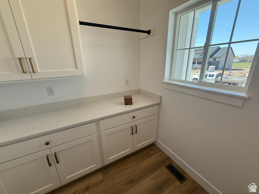 Interior space featuring baseboards, visible vents, and dark wood-type flooring