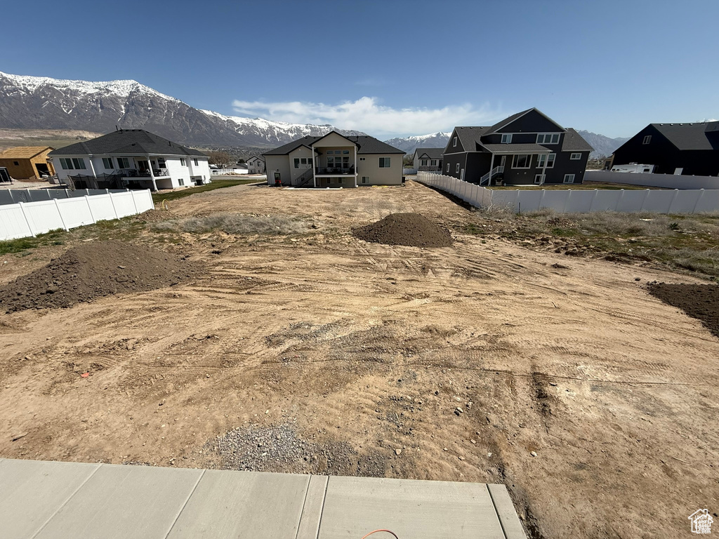 View of yard featuring fence, a residential view, and a mountain view