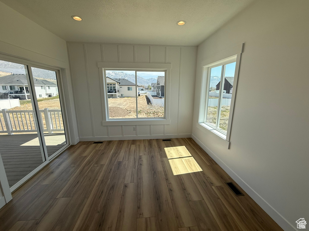 Unfurnished dining area with dark wood-style flooring, baseboards, recessed lighting, and visible vents