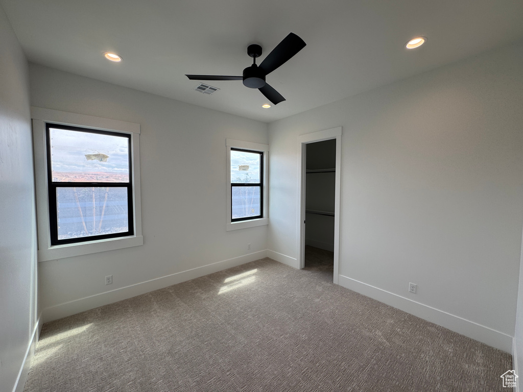 Unfurnished bedroom featuring carpet floors, baseboards, recessed lighting, and a spacious closet