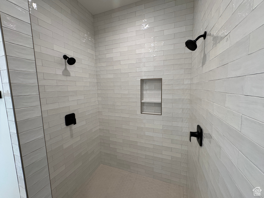 Full bath featuring tiled shower