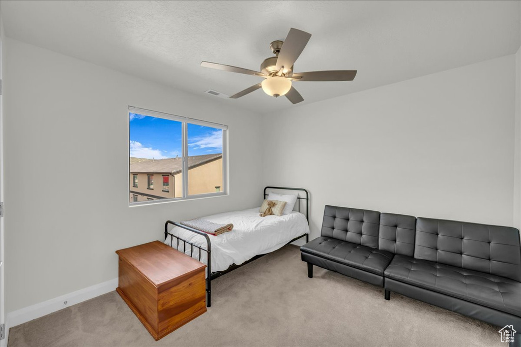 Carpeted bedroom with visible vents, baseboards, and ceiling fan