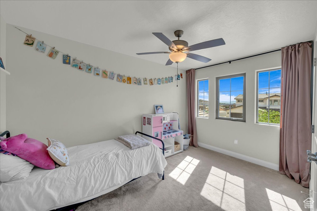 Carpeted bedroom featuring a ceiling fan and baseboards