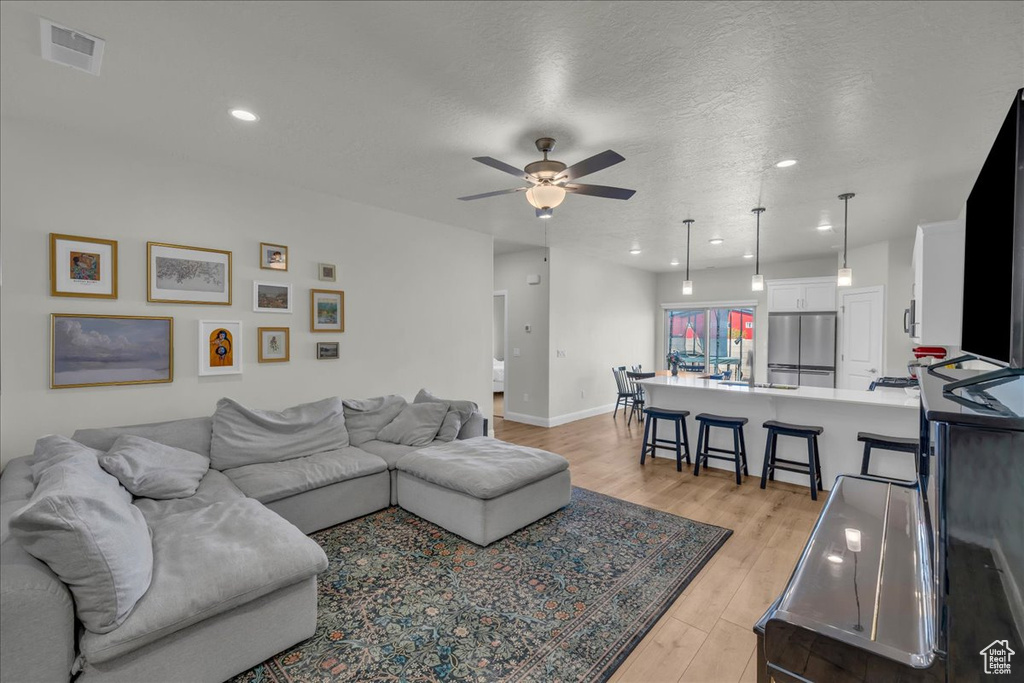 Living room with visible vents, a ceiling fan, light wood-style floors, and recessed lighting